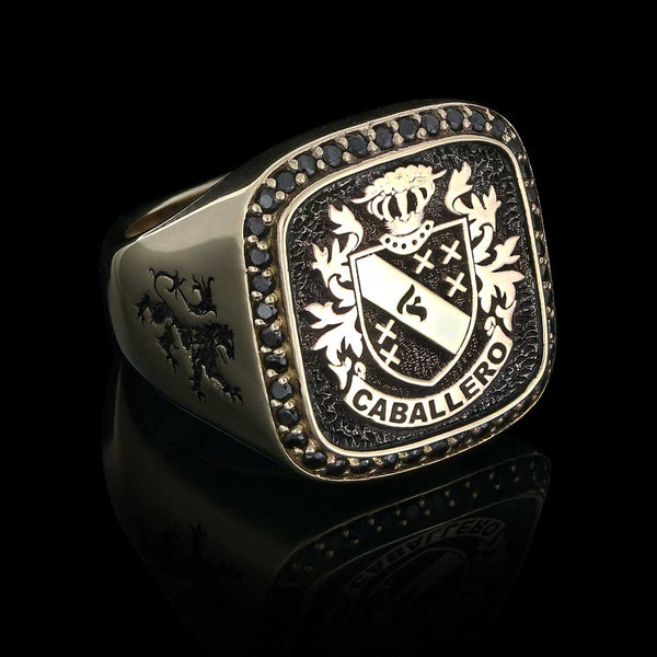 Custom gold signet ring featuring the Caballero coat of arms, detailed with a lion engraving, displayed on a sleek black background.