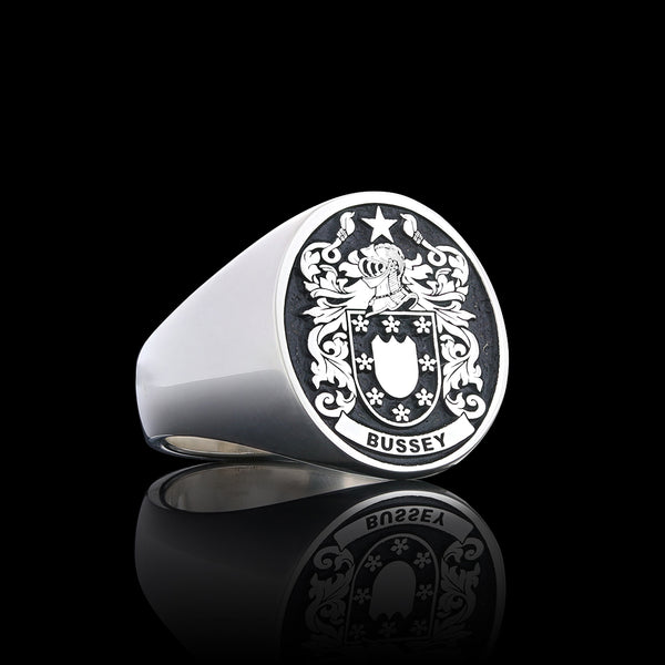 Bussey family silver signet ring with intricate detailing, showcased on a reflective black backdrop.