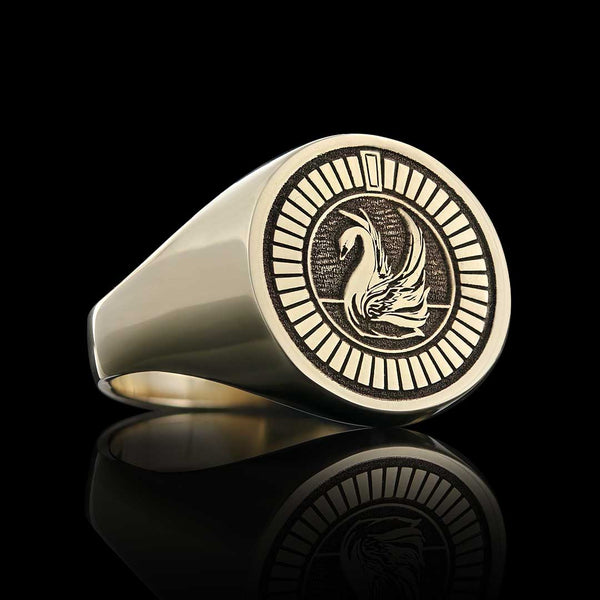 Elegant gold signet ring featuring an intricately engraved swan on a sleek black background.