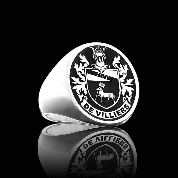 Silver ring featuring the 'De Villiers' family crest engraved, showcased on a reflective black background.