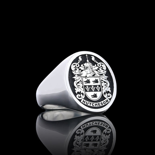 A silver ring engraved with the Hutcheson coat of arms, featuring an elegant lion crest and intricate details.