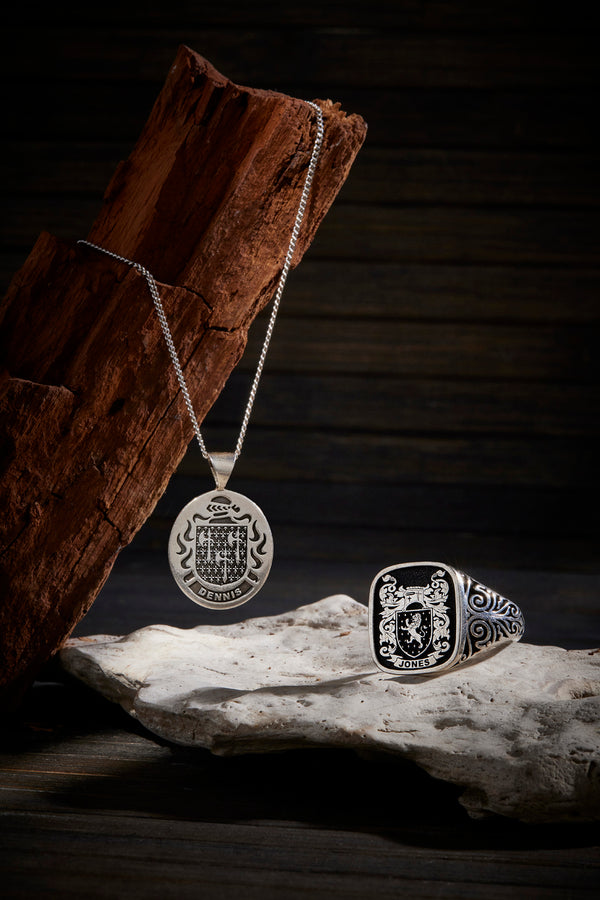 A pair of Dennis pendant and Jones signet ring displayed against rustic elements, highlighting family pride.