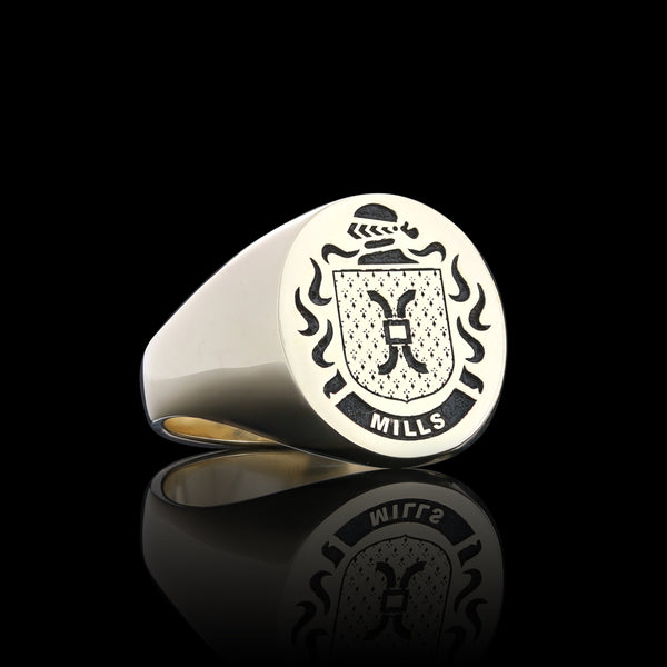 Gold signet ring engraved with the Mills family crest, reflecting tradition and legacy.