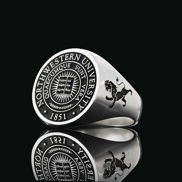 Custom silver ring featuring the Northwestern University logo, detailed with a lion engraving, on a black background.