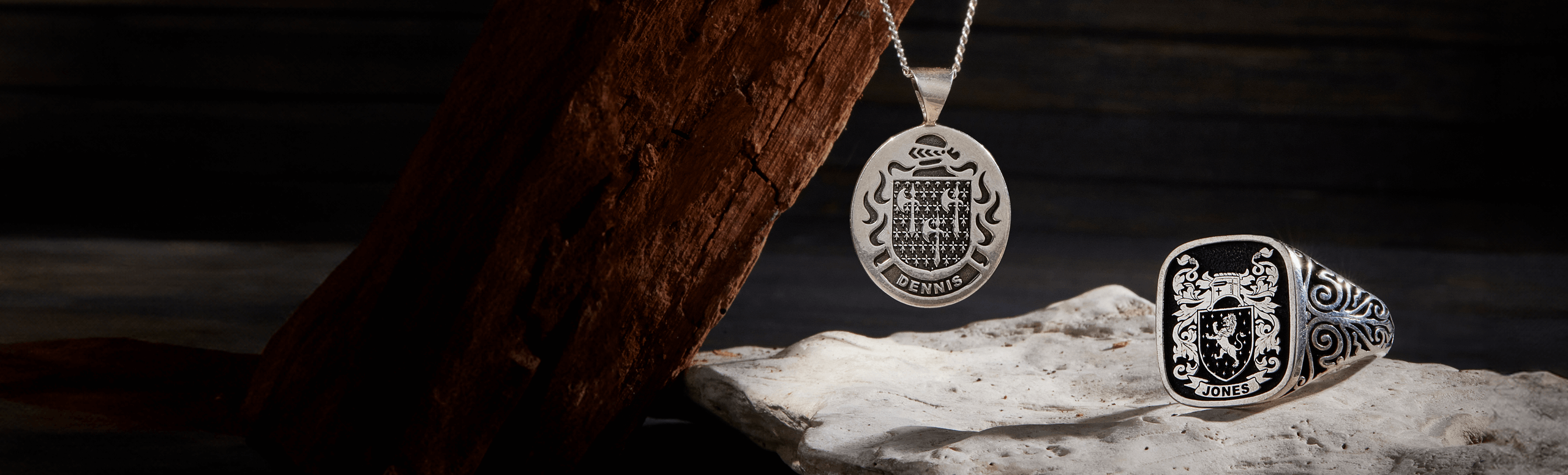 A sterling silver pendant with a crest design and a matching signet ring.