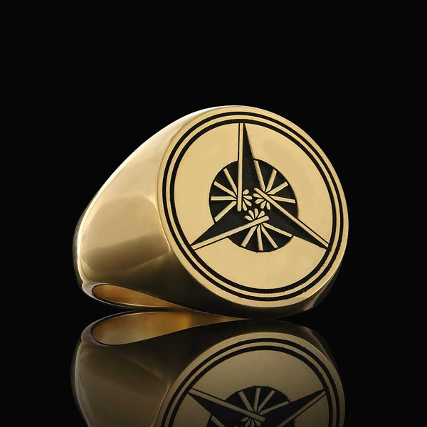 Polished gold ring adorned with a geometric crest design, exuding sophistication on a black backdrop.