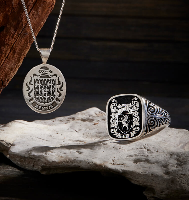 A sterling silver pendant with a crest design and a matching signet ring.