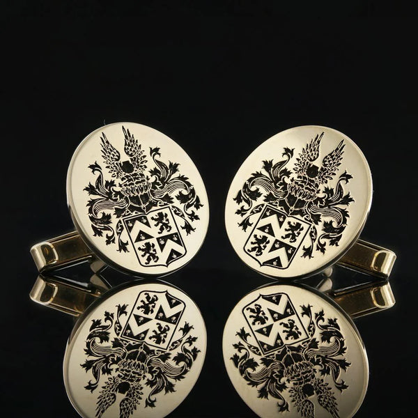 Gold cufflinks engraved with a detailed coat of arms, reflecting heritage and elegance.